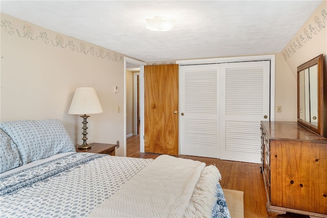 bedroom with wood finished floors and a closet
