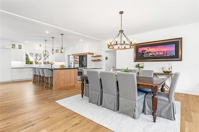 dining space featuring light wood-type flooring, recessed lighting, baseboards, and a chandelier