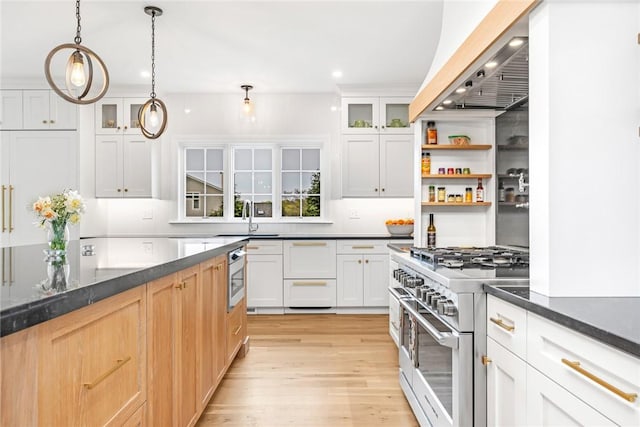 kitchen featuring range with two ovens, dishwasher, a sink, recessed lighting, and light wood-style flooring