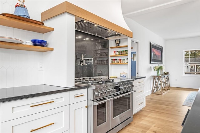 kitchen with range with two ovens, open shelves, white cabinetry, and light wood-style flooring