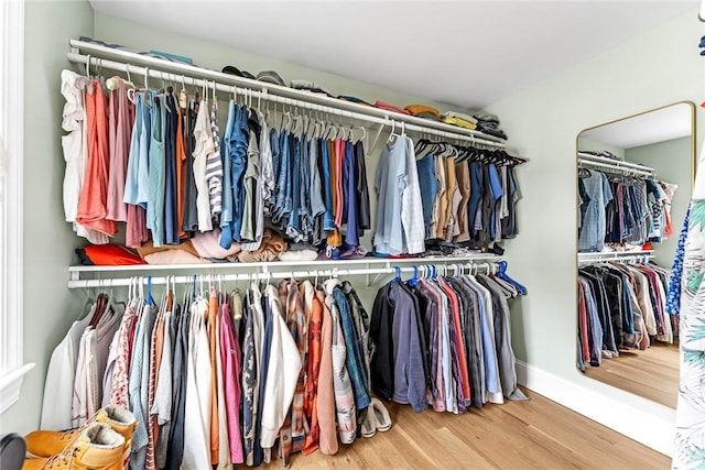 walk in closet with wood finished floors