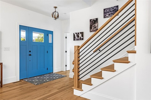 entrance foyer with baseboards, stairs, and wood finished floors