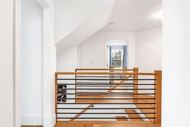 additional living space with baseboards and wood finished floors