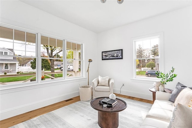sitting room with visible vents, baseboards, and wood finished floors