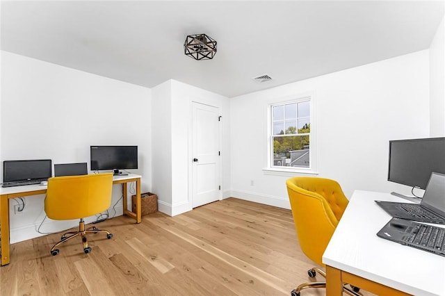 office with baseboards, visible vents, and wood finished floors