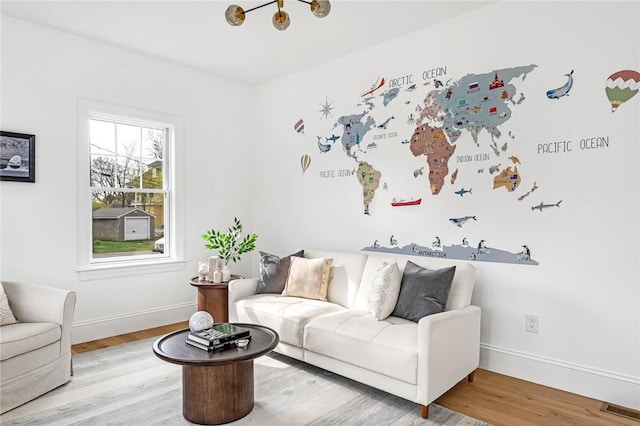 living room featuring baseboards, light wood finished floors, and visible vents