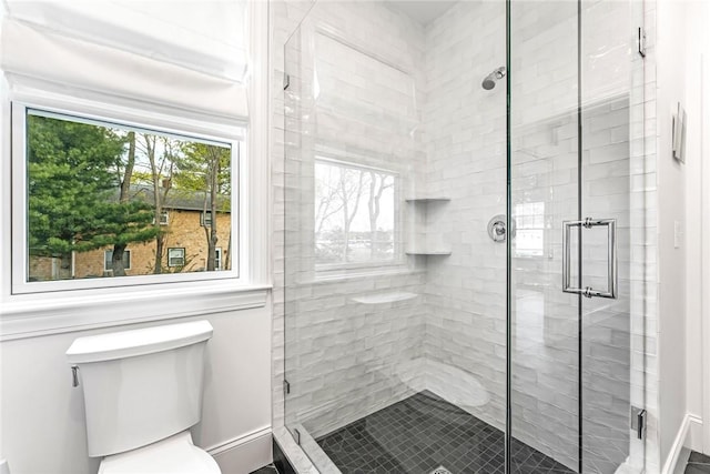 full bathroom featuring a stall shower and toilet