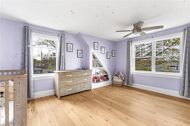 rec room featuring baseboards, a ceiling fan, and light wood-style flooring