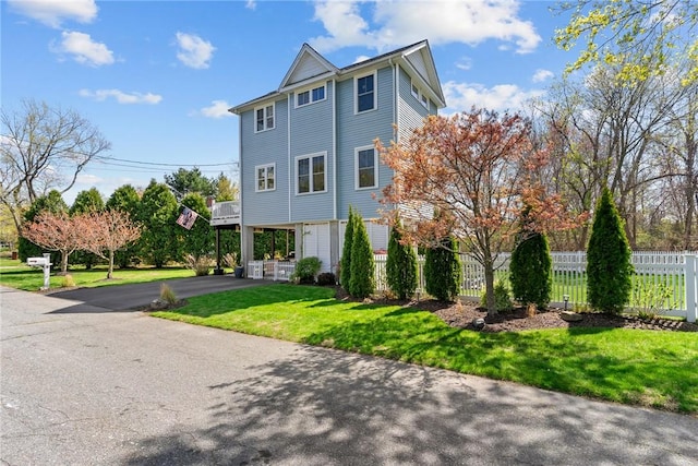 view of front of property featuring fence, driveway, and a front yard