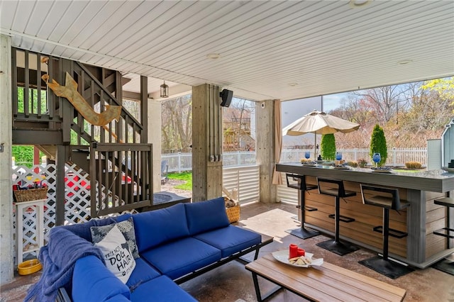 view of patio / terrace with outdoor dry bar, fence private yard, stairs, and an outdoor living space