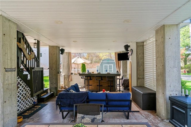 view of patio / terrace with outdoor dry bar, an outdoor hangout area, an outbuilding, and a shed