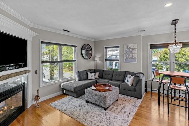 living room featuring a high end fireplace, a chandelier, visible vents, and light wood-style flooring