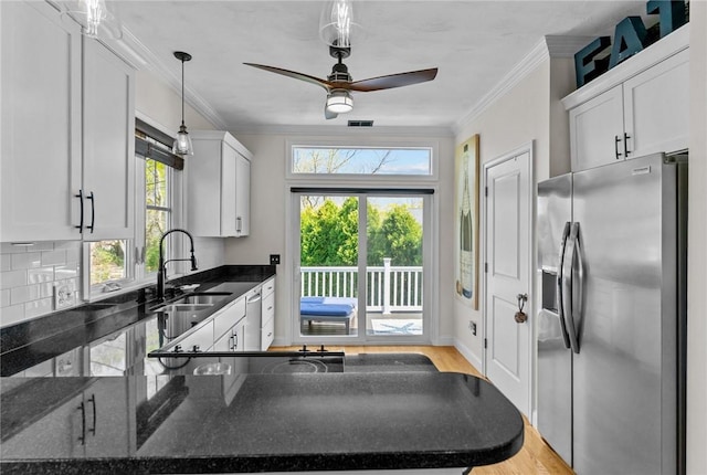 kitchen with white cabinets, backsplash, appliances with stainless steel finishes, and light wood-style flooring