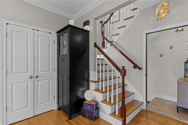 stairway featuring wood finished floors and crown molding