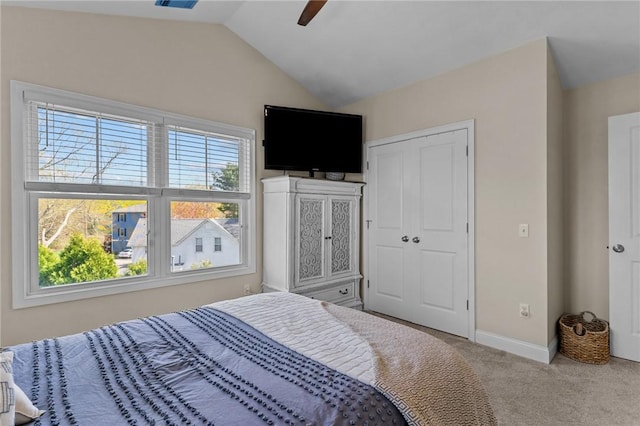 bedroom featuring lofted ceiling, carpet, a closet, and multiple windows