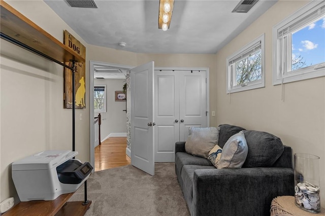sitting room with plenty of natural light, visible vents, and carpet flooring