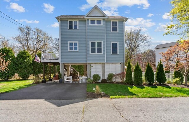 view of front of home with stairway, a front lawn, aphalt driveway, and a carport