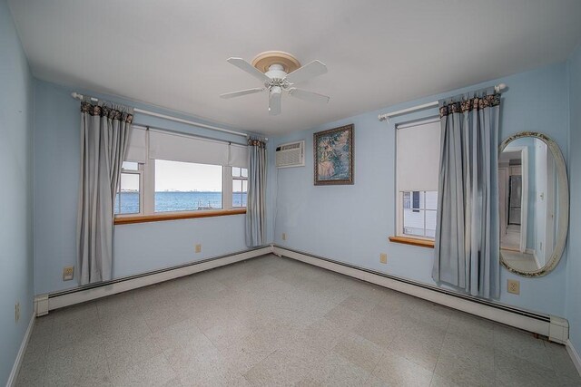 empty room featuring a baseboard radiator, baseboards, ceiling fan, and a wall unit AC