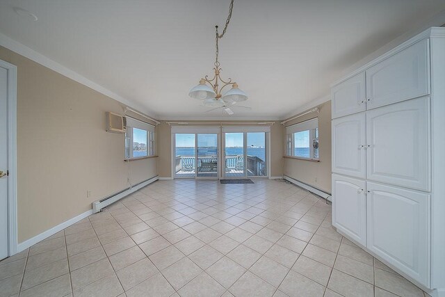 empty room with a wall unit AC, a notable chandelier, a baseboard radiator, and light tile patterned flooring