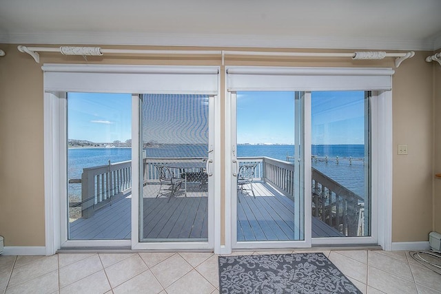 doorway to outside featuring a water view, tile patterned floors, baseboards, and ornamental molding