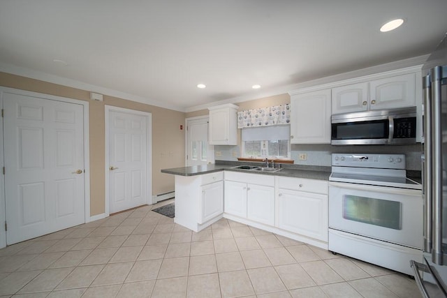 kitchen with dark countertops, a sink, stainless steel appliances, a peninsula, and white cabinetry