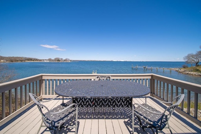 wooden deck featuring outdoor dining area and a water view