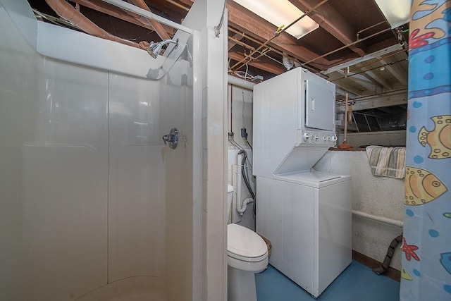 bathroom with finished concrete flooring, toilet, stacked washer and clothes dryer, and a stall shower
