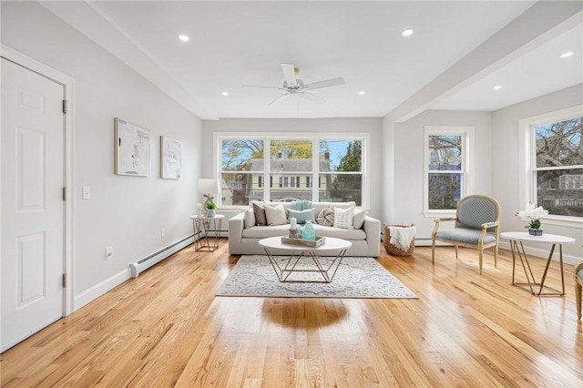 living area featuring baseboards, recessed lighting, a baseboard heating unit, a ceiling fan, and light wood finished floors
