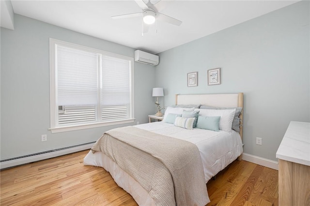 bedroom featuring baseboards, baseboard heating, a wall unit AC, a ceiling fan, and light wood-style flooring
