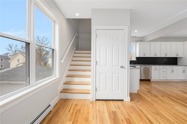 stairs featuring a baseboard radiator, recessed lighting, and wood finished floors