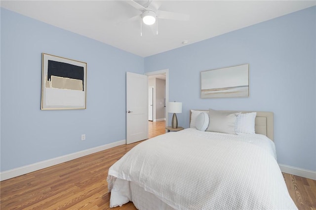 bedroom featuring baseboards, a ceiling fan, and wood finished floors