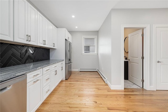 kitchen with baseboards, a baseboard radiator, white cabinetry, and appliances with stainless steel finishes