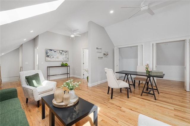 living area featuring ceiling fan, light wood finished floors, and lofted ceiling