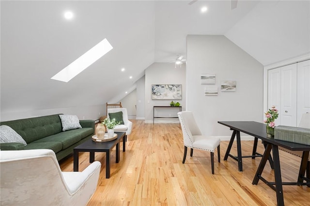 living area with baseboards, ceiling fan, recessed lighting, vaulted ceiling with skylight, and light wood finished floors