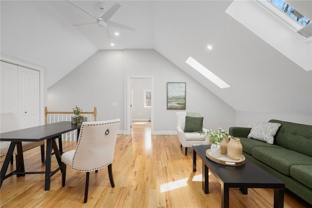 living area with recessed lighting, ceiling fan, light wood-style flooring, and vaulted ceiling with skylight