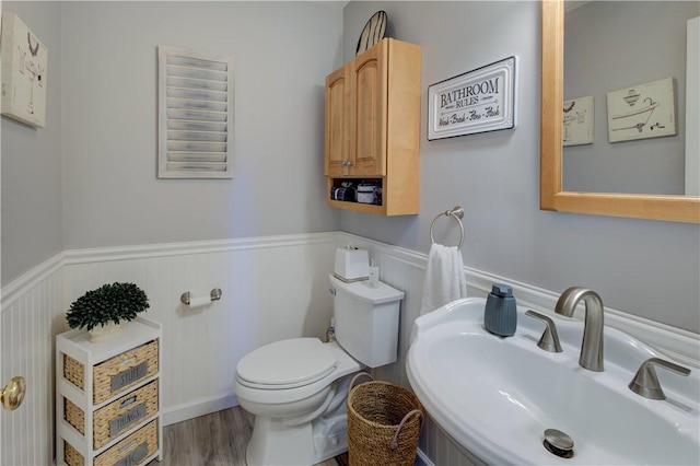 30 Rock Ridge Rd, Westerly, RI 02891 - half bathroom with toilet, wainscoting, a sink, and wood finished floors