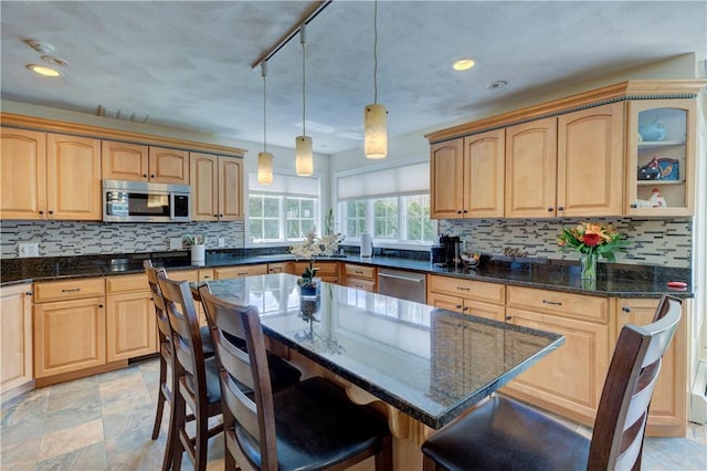 30 Rock Ridge Rd, Westerly, RI 02891 - kitchen with light brown cabinetry, a kitchen breakfast bar, dark stone counters, tasteful backsplash, and stainless steel appliances