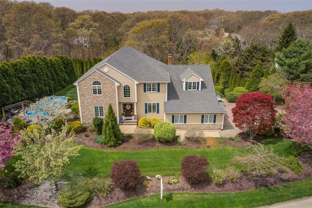 30 Rock Ridge Rd, Westerly, RI 02891 - colonial inspired home featuring a view of trees, a chimney, stone siding, and a front lawn