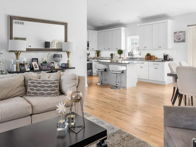 120 S Rd, East Greenwich, RI 02818 - living room with recessed lighting, lofted ceiling, visible vents, and light wood-type flooring