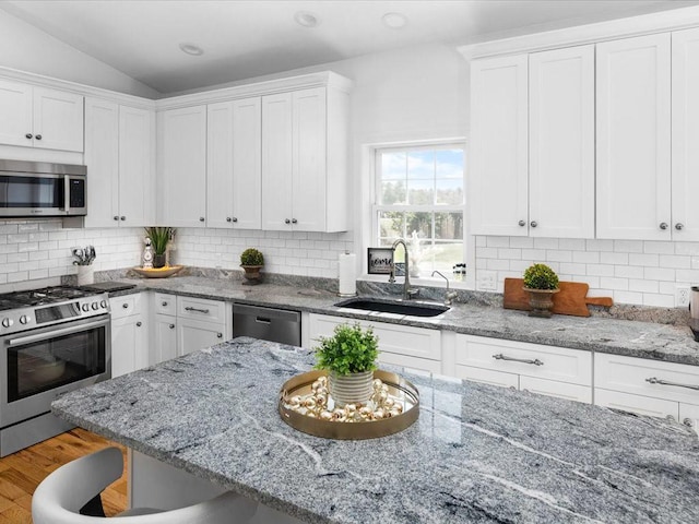120 S Rd, East Greenwich, RI 02818 - kitchen featuring a kitchen bar, white cabinets, appliances with stainless steel finishes, and a sink