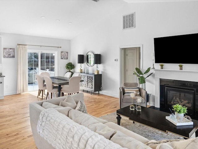 120 S Rd, East Greenwich, RI 02818 - living room featuring wood finished floors, visible vents, baseboards, a glass covered fireplace, and high vaulted ceiling