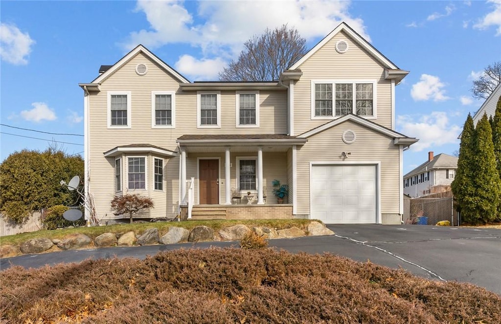 55 S St, Cranston, RI 02920 - traditional-style house with aphalt driveway, a porch, fence, and a garage