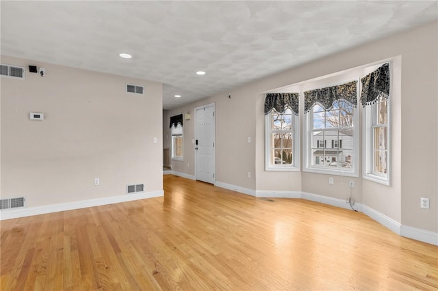 unfurnished room with baseboards and visible vents