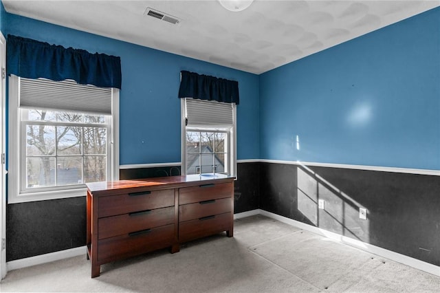 unfurnished bedroom with baseboards, visible vents, and carpet