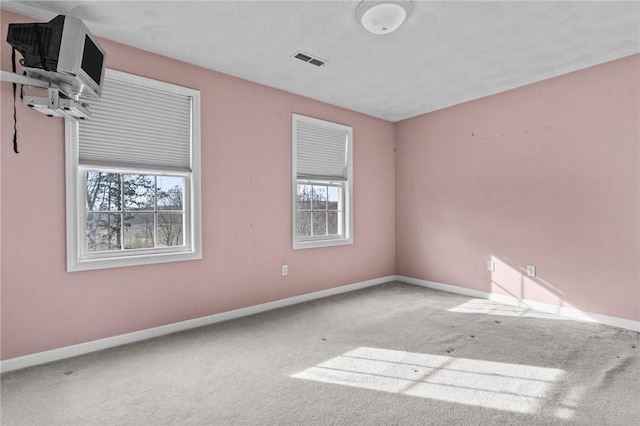 carpeted spare room with baseboards and visible vents