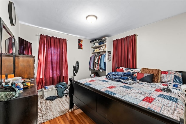 bedroom with wood finished floors and a closet