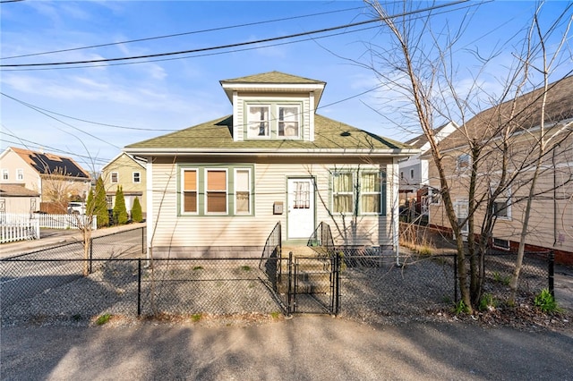 view of front of home with a gate, a shingled roof, and a fenced front yard