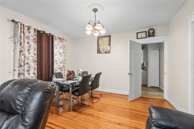 office with baseboards, a chandelier, and light wood-style floors