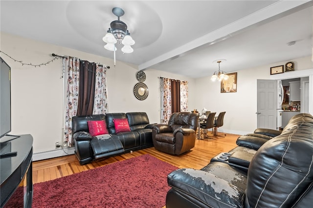 living room with beam ceiling, baseboards, ceiling fan with notable chandelier, baseboard heating, and wood finished floors