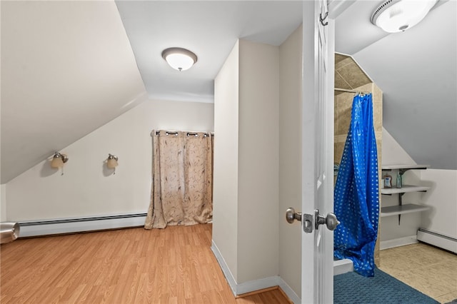 additional living space featuring lofted ceiling, baseboard heating, and wood finished floors